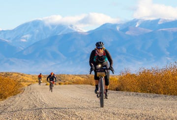 a group of people riding bikes on a dirt road