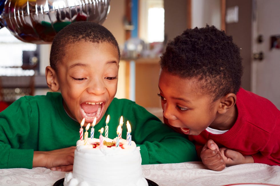 brothers boys blowing out cake candles at party