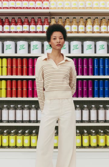 a woman standing in front of a shelf of products