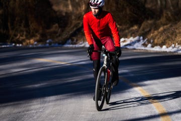 a man riding a bicycle on a road in winter