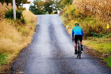 a person riding a bicycle on a gravel road