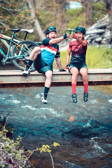 celebratory toast with beer by cyclist couple enjoying favorite hobby