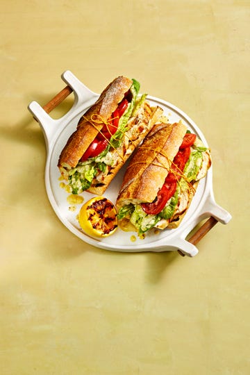 chicken caesar sandwich with tomato and lettuce on a baguette