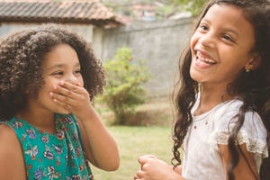 two young girls laughing in the backyard