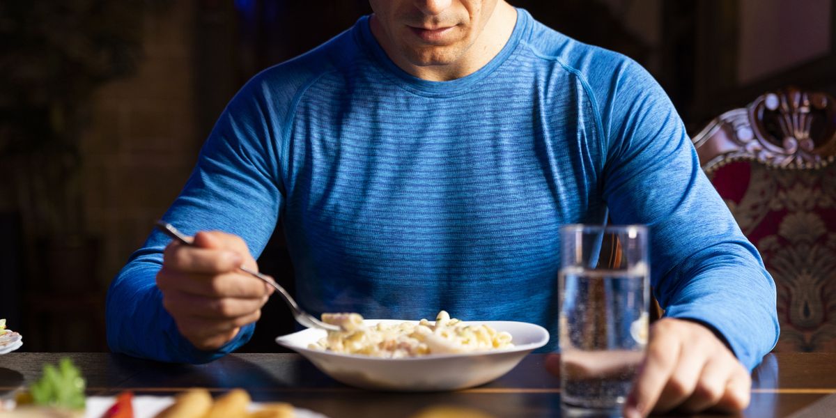 close up of athlete eating pasta dish