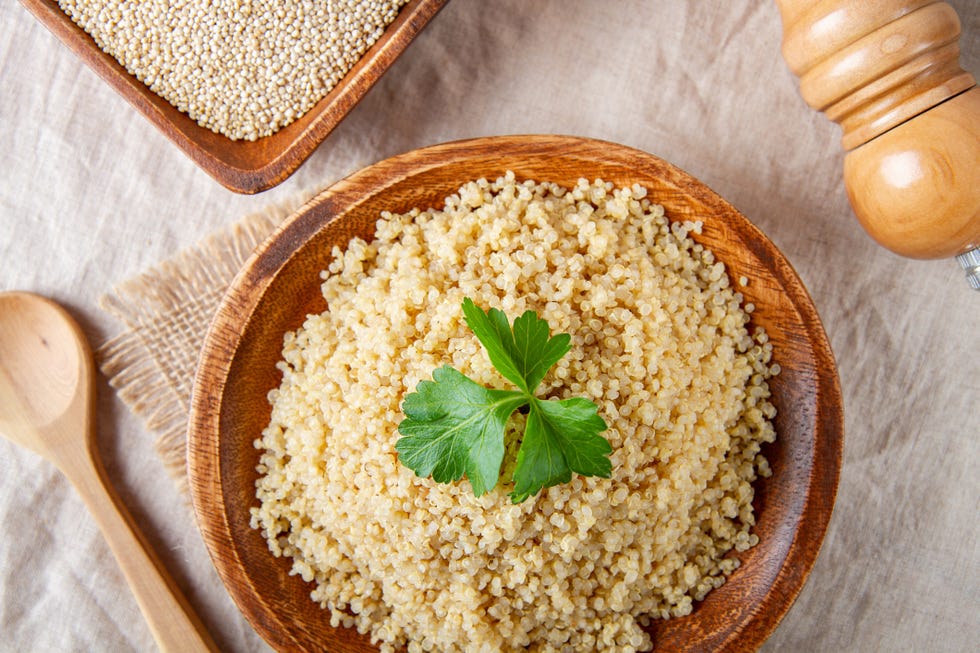 good carbs to eat, cooked quinoa in a wooden plate on the table, top view