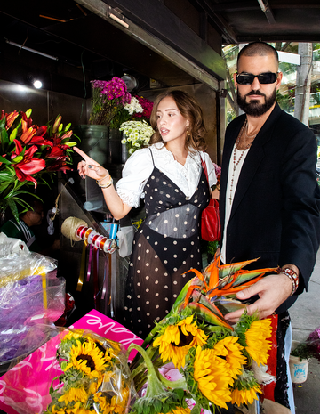 a man and woman standing next to a bouquet of flowers