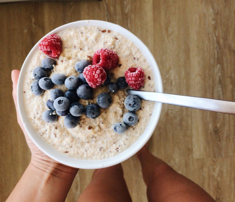 cropped hand of woman holding breakfast bowl at home