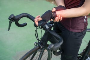 cropped shot of female cyclist holding her wrist caused of wrist pain wrist pain cycling