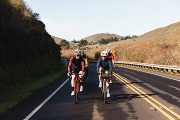 a group of people riding bikes on a road