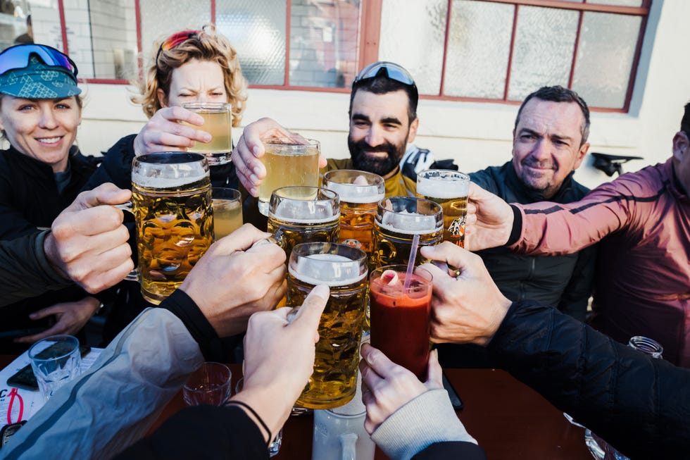 cyclists toasting with steins of beer outside brewery