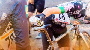 cyclist handing off beer at cyclocross event