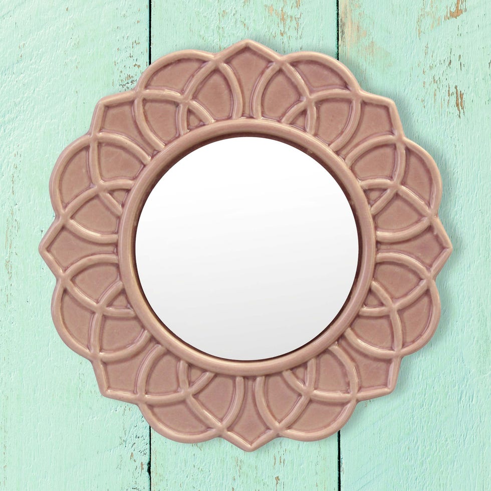 round mirror in dusty rose ceramic frame on barnwood wall painted aqua