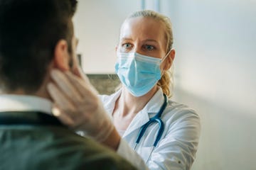 doctor wearing surgical mask examining man