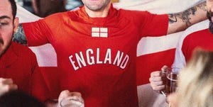 male football fans wearing england shirts and holding pints of beer with their faces obscured