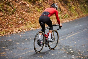 trevor raab riding uphill in the fall wearing black bibs