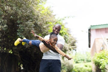 happy little girl flying as father holds her in the air