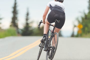 female cyclist rides along a rural highway