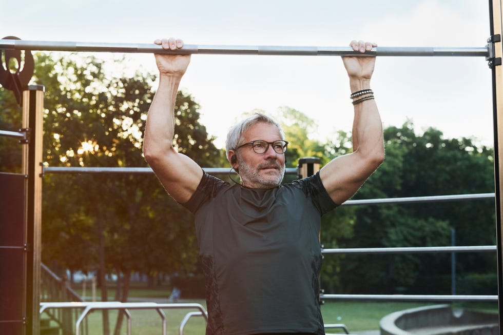 elderly handsome man exercising in an outdoor gym