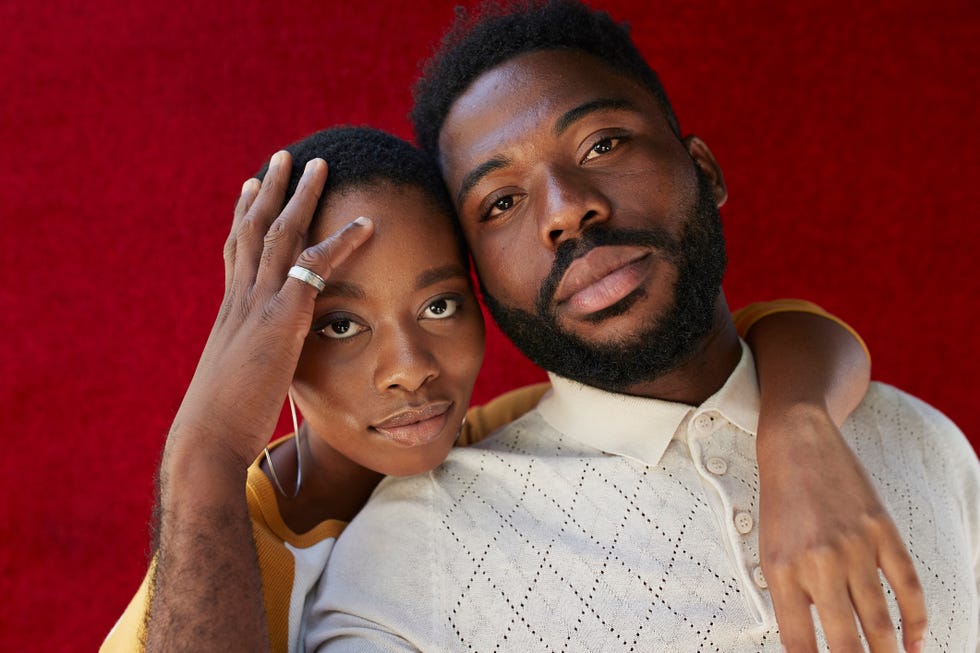 close up portrait of young man and woman against red wall