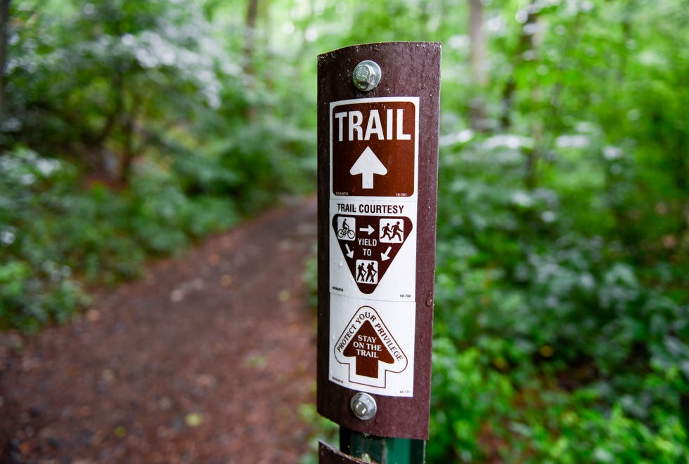 lower alsace township, pa   june 22 a trail marker that reads trail with an arrow, a graphic that reads trail courtesy with a graphic instructing people on bicycles to yield to runners and hikers, and runners to yield to hikers, then an arrow with the text protect your privilege, stay on the trail in the neversink mounatin preserve in lower alsace township tuesday afternoon june 22, 2021 photo by ben hastymedianews groupreading eagle via getty images