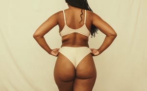 rearview of a self confident young woman adjusting her underwear in a studio anonymous young woman embracing her natural body and curves woman wearing beige underwear against a studio background