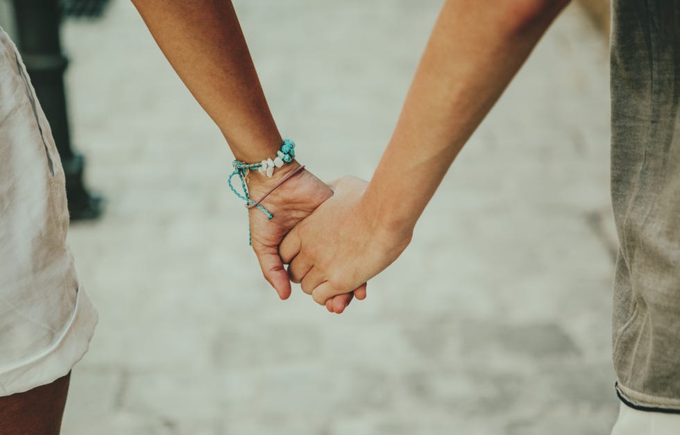 portrait of female friends with arm around outdoors on sunny day