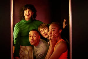 portrait of female and male friends making faces inside photo booth