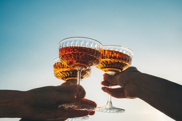 a close up shot of friends clinking sparkling wine glasses at sunset refreshing cocktail drinks summer outdoor parties and celebrations concepts