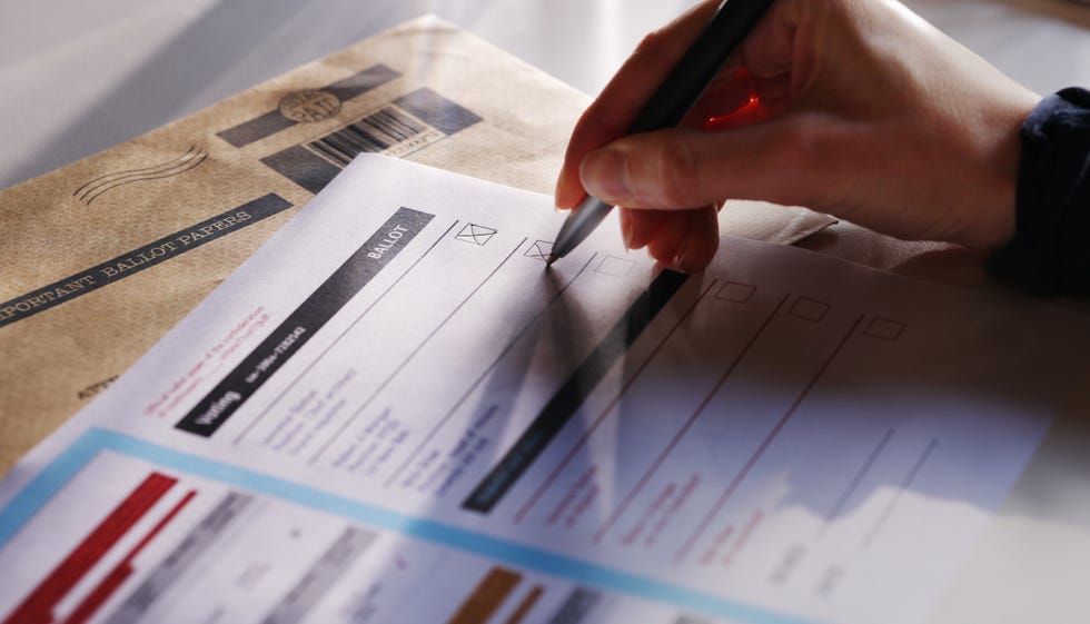 stock image showing a woman's hand filling in a postal ballot voting form