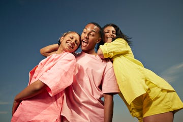 low angle view of carefree male and female friends enjoying against sky