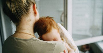 mother tenderly hugs newborn baby