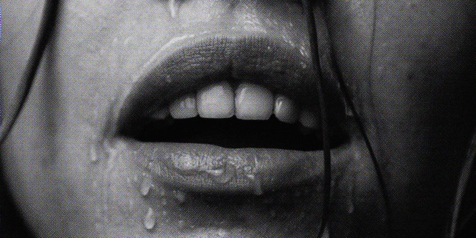 portrait of a girl's face which water flows on a dark background