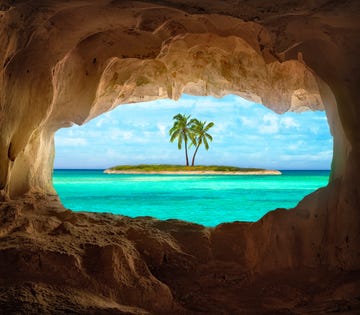 an old indian cave located on a remoteturks and caicos island beautiful caribbean sea glowing and warm sunlight bathing some remote palm trees on a deserted island