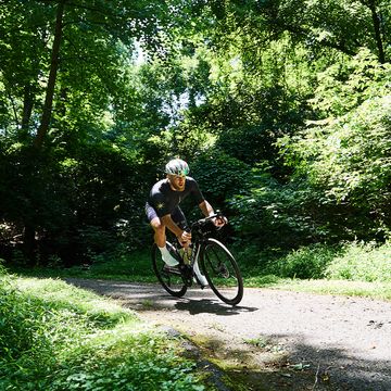 a man riding a bicycle on a trail in the woods