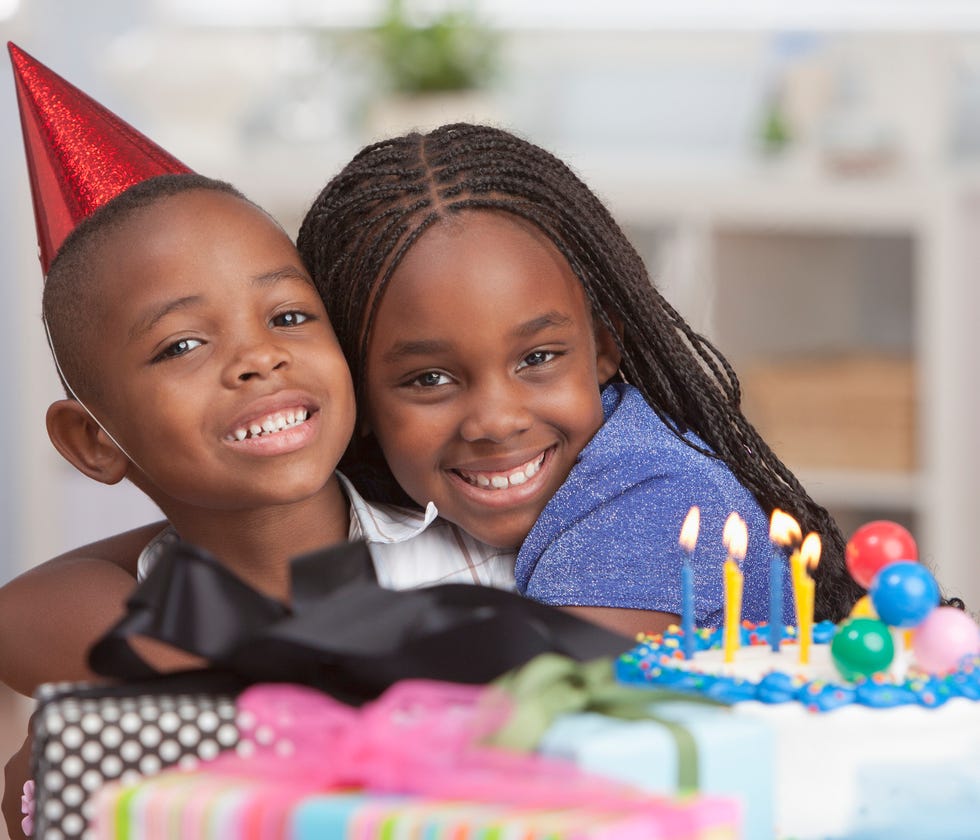 sister hugging brother in birthday hat