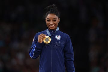 simone biles holds up her gold medal during the 2024 paris vault final