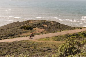 group of two cyclists riding a long stretch of road in california