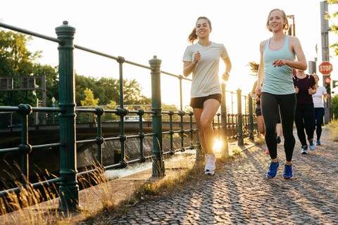 group of women running together alongside canal