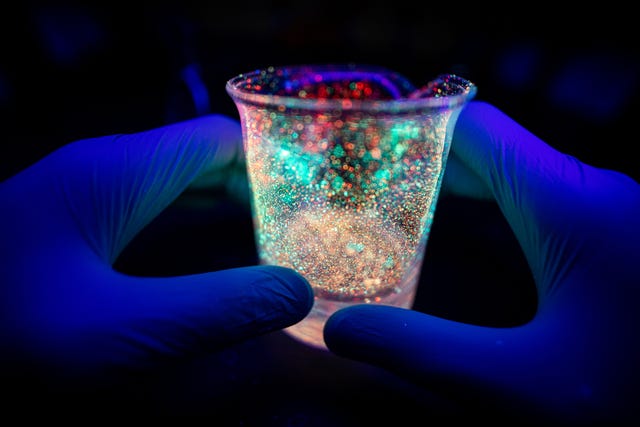 hand holding bacterial tube under uv light