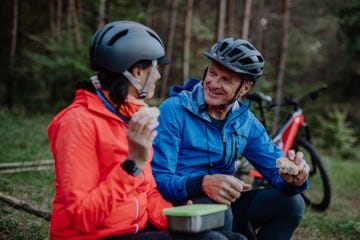 protein intake seniors happy senior couple bikers with eating snack outdoors in forest in autumn day