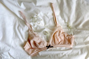 pale pink bralette and gypsophila flowers on white sheets top view