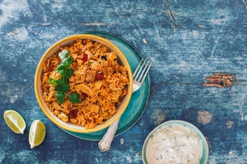 hyderabadi chicken biryani with cucumber raita on rustic table