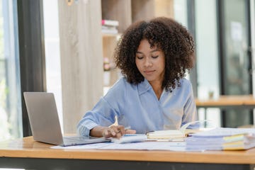 woman works on laptop as she calculates finances