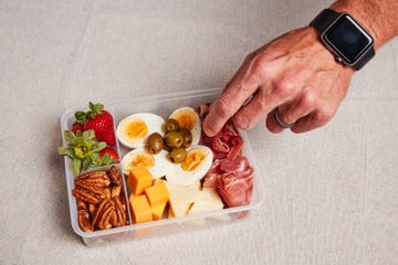 a hand reaching into a container of keto snacks