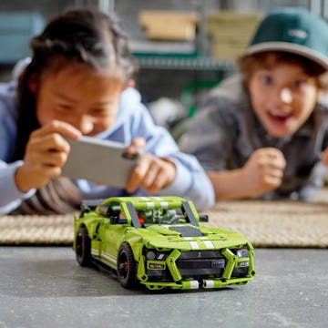 a couple of kids looking at a toy car