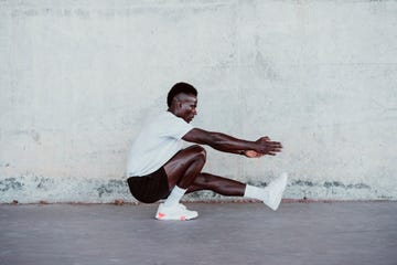 male athlete doing exercise by white wall