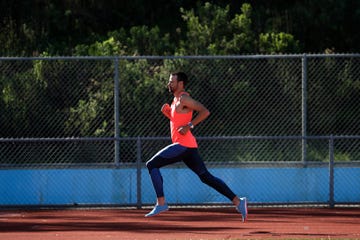 a male athlete runs on a track