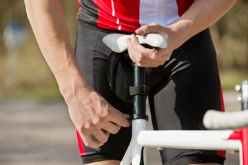 man adjusting seat of bicycle