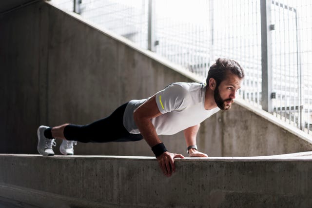 Man doing push-ups on concrete wall